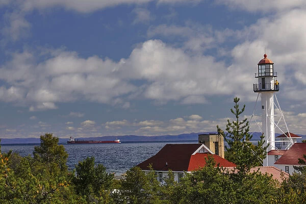 Freighter bound for Canada passing Whitefish Point Lighthouse, the oldest operating