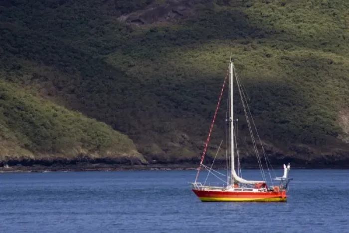 Framed Print : French Polynesia, Marquesas Islands, Nuku Hiva. Brightly colored sailboat at anchor off the coast