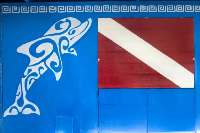 Framed Print : French Polynesia, Society Islands, Rangiroa. A dolphin and dive flag painted on Framed Print : French Polynesia, Society Islands, Rangiroa. A dolphin and dive flag painted on
