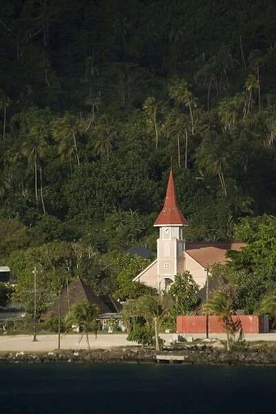 French Polynesia, Society Islands, Bora Bora. A red-roofed church at the waters edge