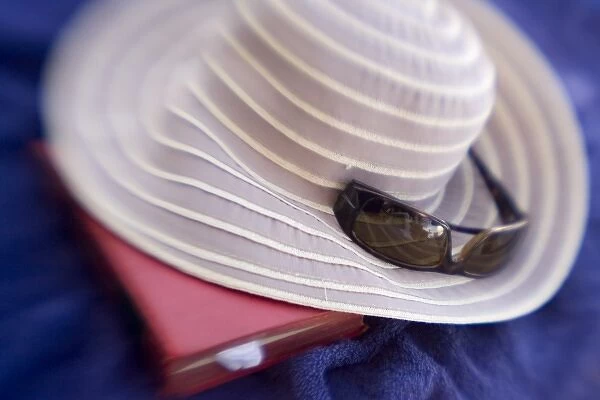 French Polynesia. Sun hat, sunglasses and book on a blue towel