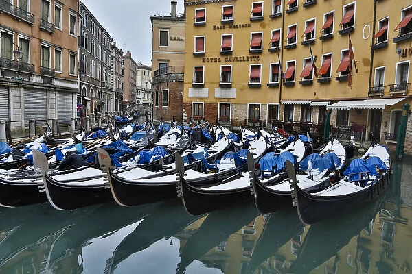 Fresh snow on Gondolas along the canals of Venice, Italy