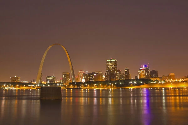 The Gateway Arch and St Louis skyline reflect into the Mississippi River at dusk in St Louis