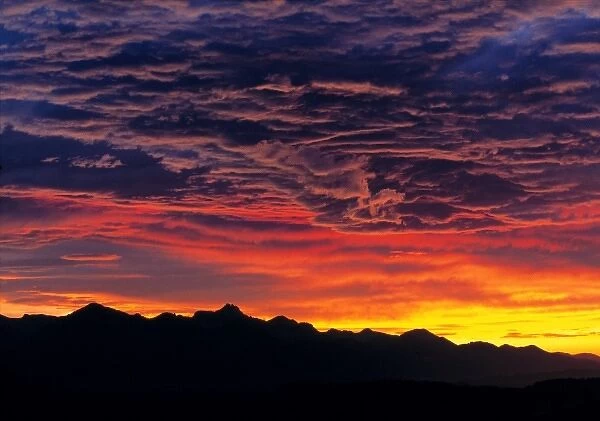Germany, Bavaria, Alps. Sunset silhouettes the jagged peaks of the Bavarian Alps