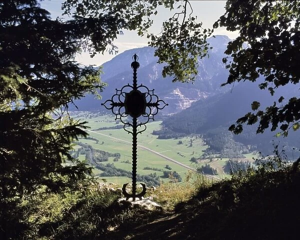 Germany, Bavaria. A wrought-iron cross looks down on a peaceful valley in Bavaria, Germany