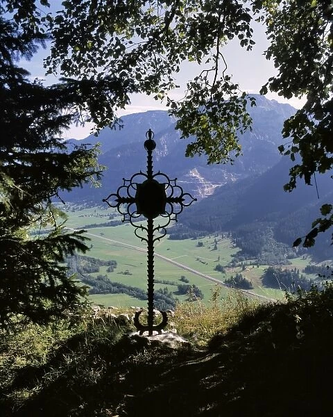 Germany, Bavaria. A wrought-iron cross occupies a secluded overlook in Bavaria, Germany