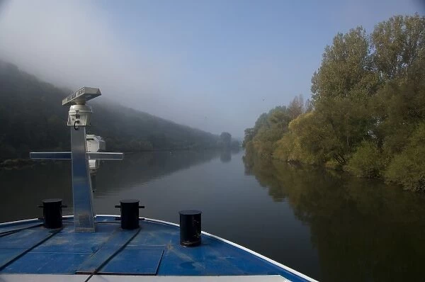 Germany, Franconia. Cruising along the Main River near Wertheim with early morning fog
