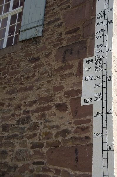 Germany, Franconia, Wertheim. Historic flood water line markers along old wall