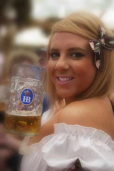 Germany, Munich. A young woman enjoys a beer at the Oktoberfest celebration