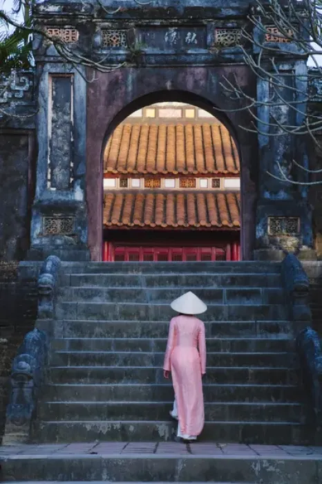 Framed Print : Girl in Ao Dai (traditional Vietnamese long dress) and conical hat at Minh Mang Tomb