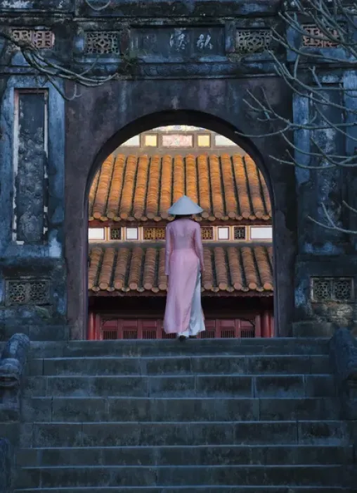 Framed Print : Girl in Ao Dai (traditional Vietnamese long dress) and conical hat at Minh Mang Tomb