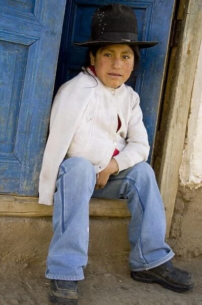 Girl sitting in doorway, Huaripampa (near Huaraz), Peru. (MR)