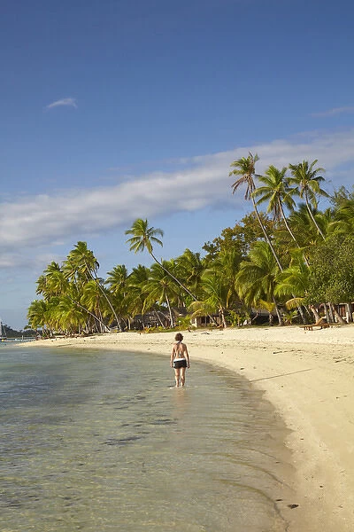 Girl walking along beach, Plantation Island Resort, Malolo Lailai Island, Mamanuca Islands
