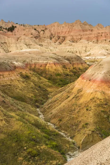 Framed Print : The grassy valley with dry creek is fed by the run off of the hoodoos lining the side