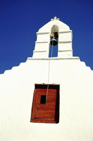 Greece, Aegean Sea, Mykonos. Typical white island church tower with bell and red door