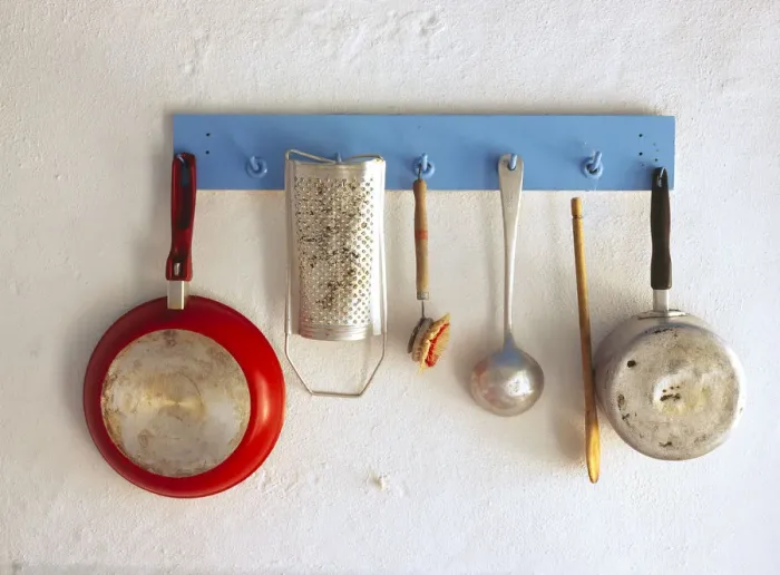 Framed Print : Greece, Corfu. Kitchen utensils hang on rack