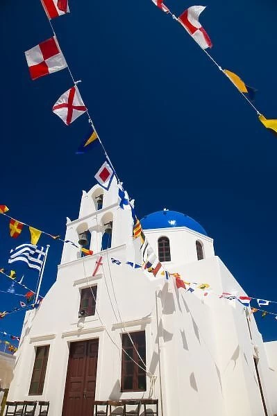 Greece and Greek Island of Santorini town of Oia Blue Domed Church with flags flying