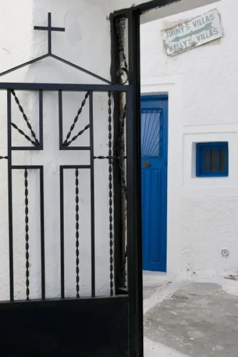 Framed Print : Greece, Santorini. Black iron church gate against white wall
