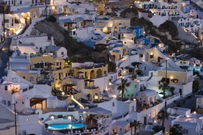 Framed Print : Greece, Santorini, Firostefani. Close-up of cliffside villas with lights coming on at nightfall