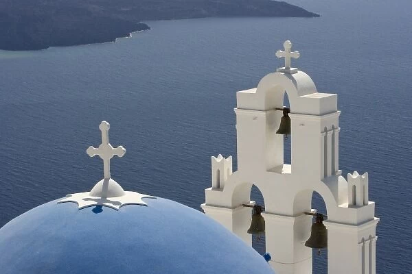 Greece, Santorini. Greek Orthodox church and white bell tower overlooking the Aegean Sea