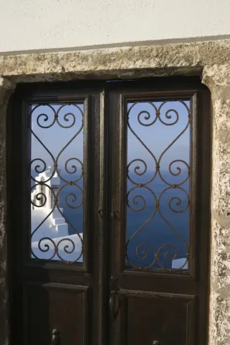 Framed Print : Greece, Santorini, Thira, Oia. Church tower seen through iron grill of door with sea in background