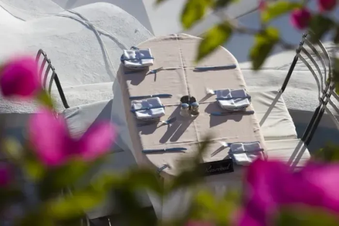 Framed Print : Greece, Santorini, Thira, Oia. Looking through bougainvillea to a patio table set for dinner