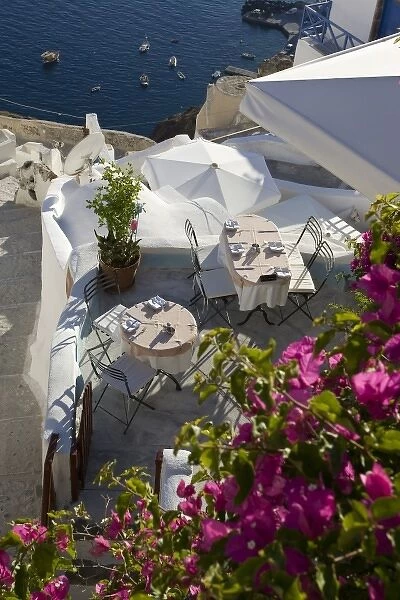 Greece, Santorini, Thira, Oia. Looking down on patio tables set for dinner