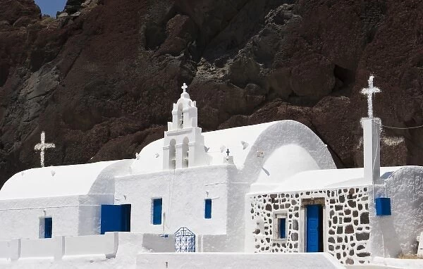 Greece, Santorini. White Greek Orthodox church starkly contrasts with red cliff