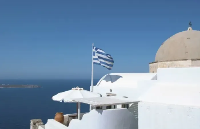 Framed Print : Greek flag flying on porch of white home on steep clifees of Fira in Santorini in Framed Print : Greek flag flying on porch of white home on steep clifees of Fira in Santorini in