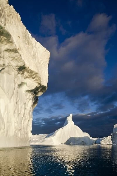 Greenland, Ilulissat, Midnight sun lights massive icebergs calved from Jakobshavn
