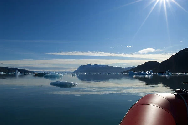 Greenland, Tunulliarfik Fjord. A rubber raft navigates through a sea of icebergs