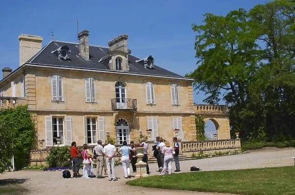 A group of visiting wine tasters in the garden in front of the chateau Chateau Kirwan