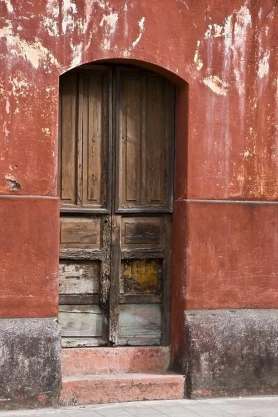 Guatemala, Antigua. Exterior wall and wooden door along the streets of Antigua