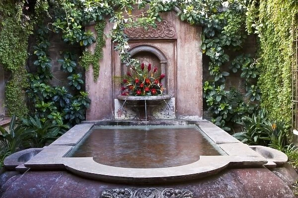 Guatemala, Antigua. Fountain decorated with flowers in a hotel in the town of Antigua