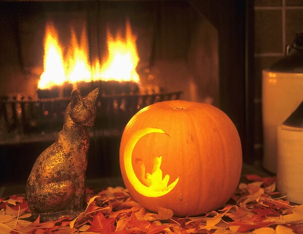 Halloween themed image of ceramic cat facing carved pumpkin with a cat on the moon