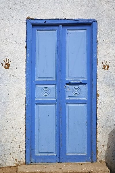 Hand prints on each side of blue doorway. Small rural village outside of Luxor, Egypt