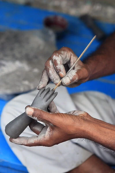 Hands working on a hand in the potters village of Kumartuli in Calcutta