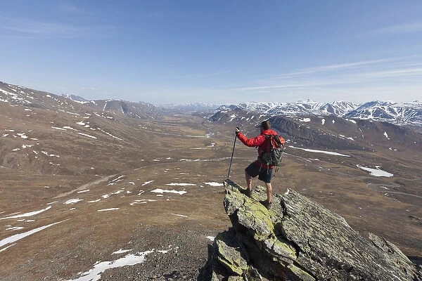A hiker looks across the upper Nigu River Valley in Gates of the Arctic National Park and Preserve