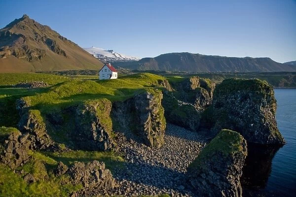 House near basaltic columns with Snaefellsjokull Volcano in the background