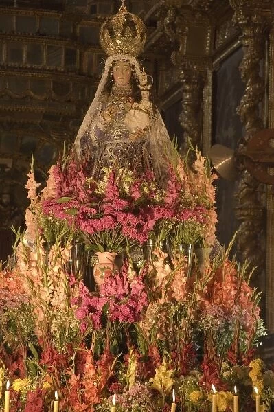 Huge display of flowers and candles under statue of Virgin Purificada, Church of Santa Clara