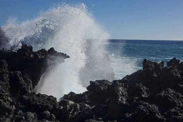 Huge waves crashing against lava rocks on coast of Big Island, Hawaii