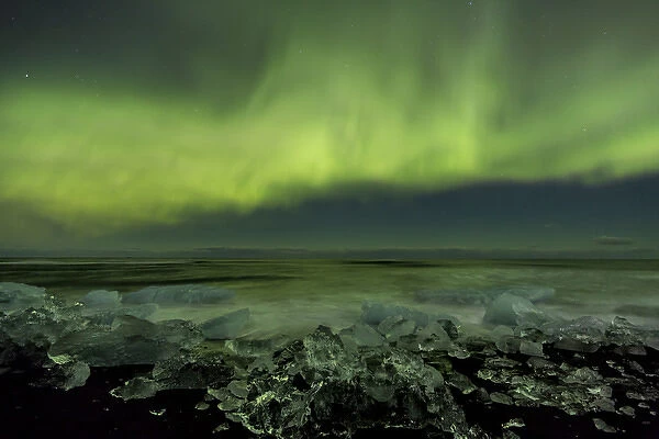 Iceland, Jokulsarlon. Aurora borealis and ocean shore