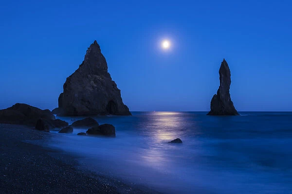 Iceland, Reynisdrangur. Moonrise reflection on ocean and seastacks