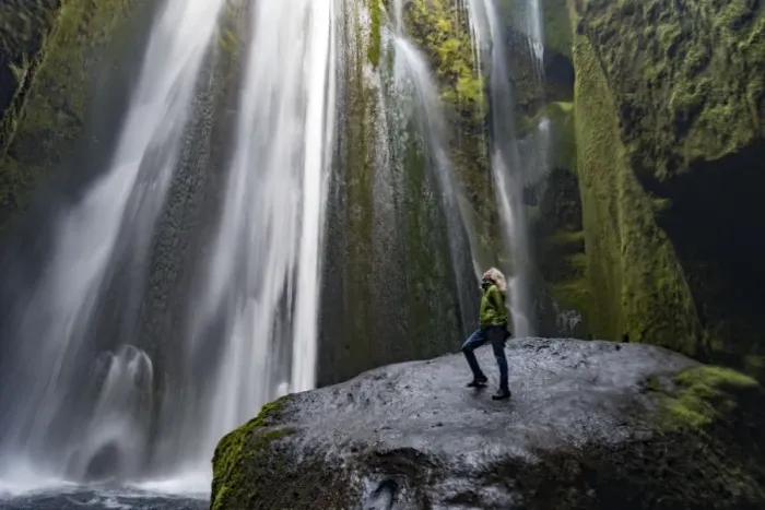 Framed Print : Iceland, Seljalandsfoss, woman standing on large rock in front of streaming falls Framed Print : Iceland, Seljalandsfoss, woman standing on large rock in front of streaming falls