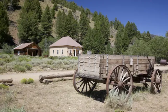 Framed Print : ID, Custer, (1880s gold mining town) Freight wagon; with schoolhouse / museum Framed Print : ID, Custer, (1880s gold mining town) Freight wagon; with schoolhouse / museum