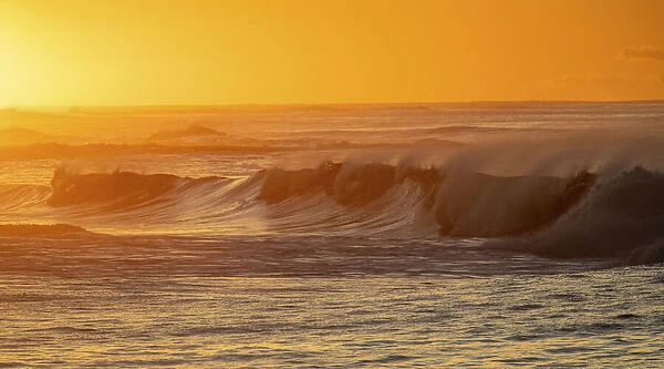 Incoming surf waves at sunrise near Poipu in Kauai, Hawaii, USA