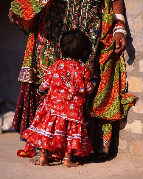 India, Gujurat. Shy child hugs Megwar Tribe woman mother
