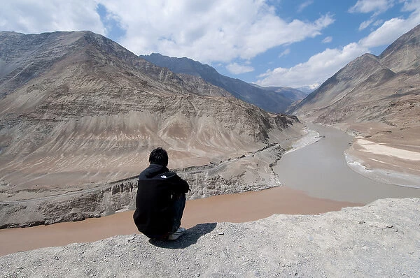 India, Jammu & Kashmir, Ladakh, man sitting above the Zanskar and Indus River confluence