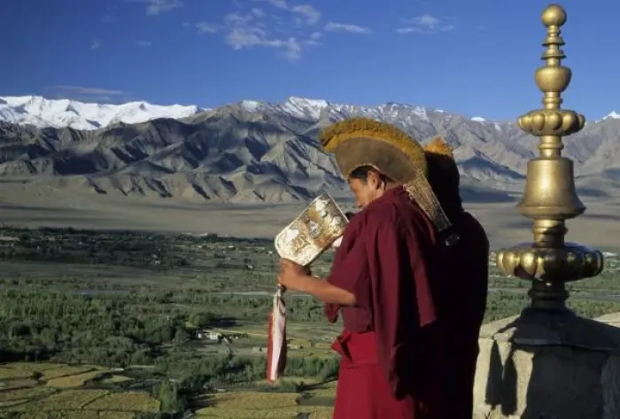 Framed Print : India, Ladakh, Thikse. Buddhist monk blows conch horn announcing prayers from rooftop Framed Print : India, Ladakh, Thikse. Buddhist monk blows conch horn announcing prayers from rooftop