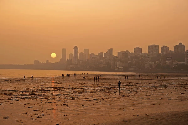 India, Maharashtra, Mumbai, Chowpatty beach, sunset with red sun coming down under